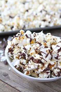 a bowl filled with chocolate and marshmallows on top of a wooden table