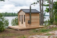 a small wooden cabin sitting next to a lake