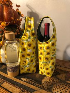 two sunflowers are on the table next to some wine bottles and pumpkins