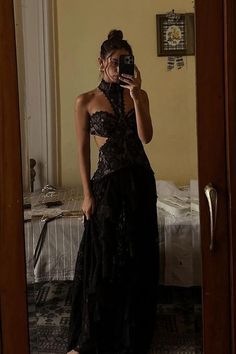 a woman in a black dress taking a selfie