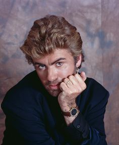 a close up of a person with a watch on his wrist and wearing a suit