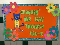 a bulletin board with flowers and a cat on it