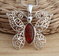 This is 925 Sterling Silver Pendant & Genuine Baltic Amber .      925 stamped            Amber size: 8 mm x 18 mm            Amber colour: cognac Approx. pendant measures:                 length: 36 mm                width: 40 mm in its widest part Approx. weight: 5.0gr. pendant only.                                         Available on its own or with various length (16-26 Inch ) snake chain, please choose from the drop down menu at the top of the page. Presented in gift box. Thank you for look Classic Orange Jewelry As Gift, Classic Orange Jewelry For Gift, Classic Orange Necklace For Gift, Classic Orange Necklace For Gifts, Classic Amber Necklace As Gift, Amber Hallmarked Necklaces For Gifts, Classic Amber Necklace Gift, Classic Amber Necklace For Gift, Orange Polished Finish Jewelry For Gift