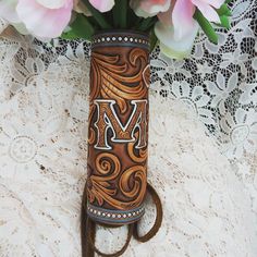 a vase with some flowers in it on a lace tablecloth next to pink roses