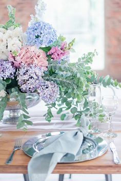 the table is set with silverware and flowers