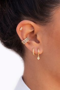 a woman wearing gold ear cuffs with two rows of diamonds on each side of her ear