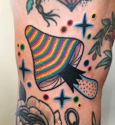 a man's leg with colorful tattoos on it