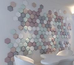 the wall is decorated with hexagonal tiles and white chairs in front of it