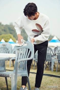 a woman ironing an outdoor table with chairs in the background