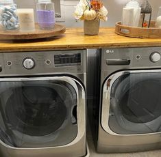 two washers sitting next to each other on top of a wooden counter in a room