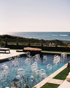 an outdoor swimming pool with clear bubbles floating in the water