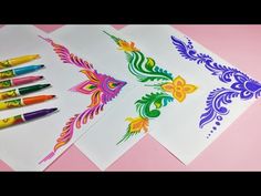 three different colored markers are next to each other on white paper with colorful flowers and leaves