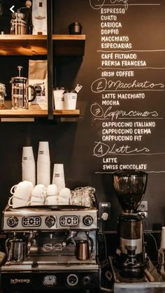 a coffee shop with menu written on the wall and various types of espresso machines