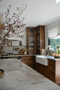 a kitchen with marble counter tops and wooden cabinets