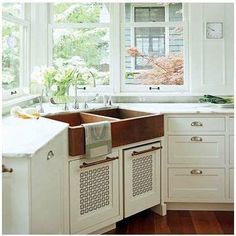 a kitchen with white cabinets and an open window over the sink is pictured in this image