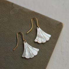 These beautiful Art Deco earrings are pure Mother of Pearl which has been carved into a simple scalloped fan shape. The pearl has an incredible sheen and take on a subtle glow when they catch the light. They are finished with gold plated earwires and are designed to hang just below the earlobe. The length of the earrings is around 45mm (just under two inches). 🖤 FASTER SHIPPING 🖤 Need this fast? We offer a Faster Shipping option here: https://www.etsy.com/uk/listing/100107311/faster-shipping-p Elegant Shell-shaped Wedding Earrings, Elegant Shell-shaped Jewelry With Ear Wire, Elegant Shell-shaped Earrings For Gift, White Art Deco Earrings For Anniversary, Gold Art Deco Earrings, Egyptian Necklace, Art Nouveau Earring, Wedding Day Jewelry, Deco Earrings