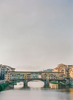 a bridge over a body of water with buildings in the background