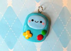 a blue toy with a smiling face on it's face is hanging from a chain