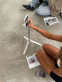 a woman sitting on the ground holding an electronic device