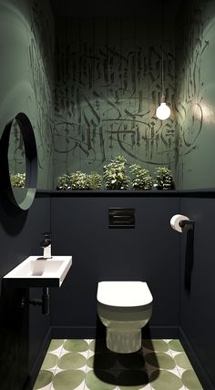 a toilet and sink in a room with graffiti on the wall next to each other