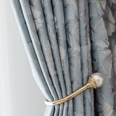 a curtain with a gold handle hanging from it's side