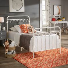 a bedroom with gray walls and white bedding has an orange rug on the floor