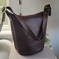 Stunning Deep Mahogany Color In The Largest Size Coach Duffle Bag Made. Made In 1997 In Usa , The Leather Is Soft And In Excellent Vintage Condition. *Inside Zippered Pocket *Original Hang Tag *15" Max Strap Drop With 4 Adjustable Lengths *13"Lx13"Wx9"W *Polished Brass Hardware The Bag Has Been Cleaned And Conditioned And Ready To Wear. Please Note That There Is A Tiny White Mark And Some Minor Discoloration On Part Of The Bottom Rim. Please See All Pictures. Coach Luxury Bucket Bag For Everyday, Classic Coach Bucket Bag For Daily Use, Classic Coach Bucket Bag For Everyday Use, Luxury Coach Bucket Bag For Everyday, Classic Bucket-shaped Bag With Leather Lining, Classic Bucket Shaped Bag With Leather Lining, Classic Bucket Shape Shoulder Bag, Classic Bucket Bag, Classic Coach Rectangular Bucket Bag