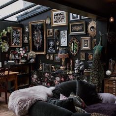 a living room filled with lots of furniture and pictures on the wall next to a desk