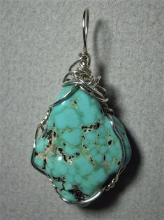 Turquoise Nugget Pendant Wire Wrapped in .925 Sterling Silver Round Wire This inspiring stone offers a few small pebbles of golden pyrite nestled inside a light to medium turquoise-blue and black patterned background. Best worn with blue, green, coral, orange, or red; but quite versatile, and many dark, bright, pastel, and earth tone colors also wear well, especially black, grays, brown, beige/tan, and lavender. A similar color of turquoise will blend, so should be avoided. Some darker purple co Artisan Turquoise Necklace With Large Stone, Healing Howlite Turquoise Jewelry, Healing Turquoise Howlite Jewelry, Turquoise Chrysocolla Necklace With Stones, Turquoise Chrysocolla Stone Necklace, Spiritual Turquoise Jewelry With Large Stone, Sterling Silver Turquoise Ring With Stones, Unique Turquoise Nickel-free Necklace, Unique Nickel-free Turquoise Necklace