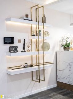 a white and gold shelving unit in the corner of a room with shelves on both sides