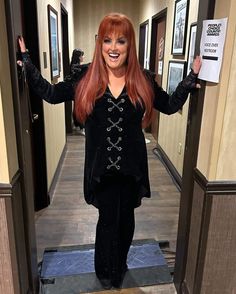 a woman with red hair is standing in an elevator