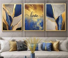 three paintings on the wall above a couch in a living room with white furniture and gold accents