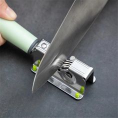 a person is holding a knife with green handles