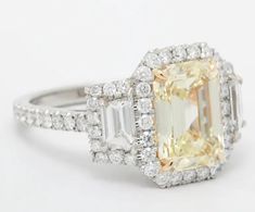 an engagement ring with a yellow diamond and two baguets on the side, surrounded by diamonds