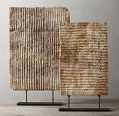 two pieces of woven material sitting on top of each other in front of a white wall