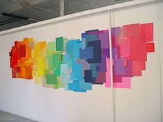 an art work is displayed on the wall in front of a white panel with colorful squares