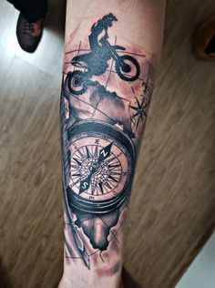 a man's arm with a compass and a horse tattoo on the left forearm