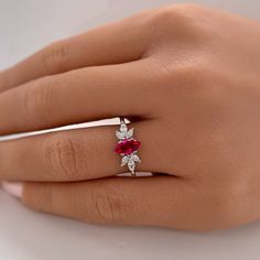 a woman's hand with a diamond and ruby ring