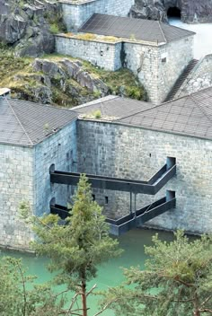 an aerial view of a building with stairs leading up to the roof and water below