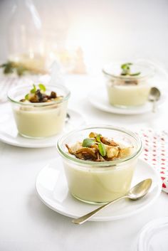 three small bowls filled with food on top of a white table