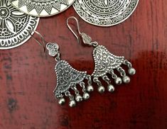 Egyptian Siwa Silver Earrings These stunning Egyptian Silver earrings are handmade by Artisan Silversmiths in the Siwa Oasis of Egypt which is renowned for incredible jewellery. These  lovely unusual  bell shaped with ornate detail and silent baubles are simply stunning. The quality is excellent.♥️ Egyptian jewellery presented in my store is authentic. ♥️ These genuine, ornately detailed vintage tribal earrings are in high demand so be quick!  Many thanks for stopping by. I'm always available to Traditional Dangle Jewelry With Artistic Design, Traditional Wedding Earrings With Artistic Design, Traditional Handmade Sterling Silver Chandelier Earrings, Traditional Earrings With Artistic Design For Festivals, Bohemian Festival Earrings With Bells, Bohemian Bell Earrings For Festivals, Traditional Artistic Design Earrings For Festivals, Traditional Festival Plug Earrings Nickel Free, Handmade Sterling Silver Chandelier Earrings For Festivals