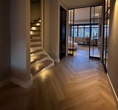 an empty room with wooden floors and stairs