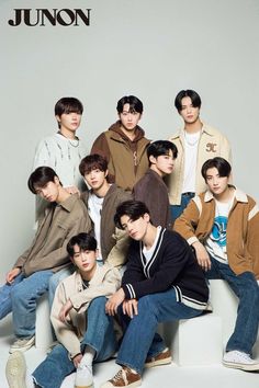 a group of young men sitting next to each other in front of a white background