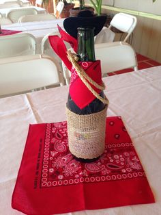 a wine bottle wrapped in twine and tied to a burlock on top of a table