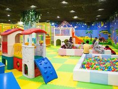 children playing in an indoor play area with colorful walls and flooring, while adults watch