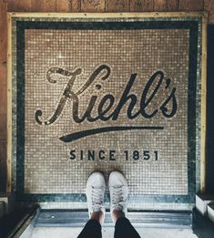 a person standing in front of a sign with their feet on the ground next to it