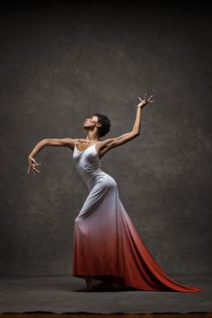 a woman in a white and red dress with her arms spread out to the side