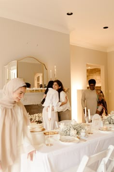 a group of people standing around a table with plates and cups on top of it