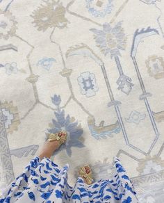 a woman in blue and white dress laying on top of a rug with her feet up