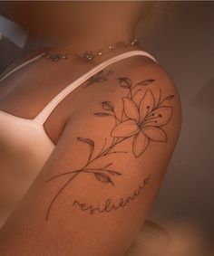 a woman's arm with a flower tattoo on it and the word believe written in cursive writing